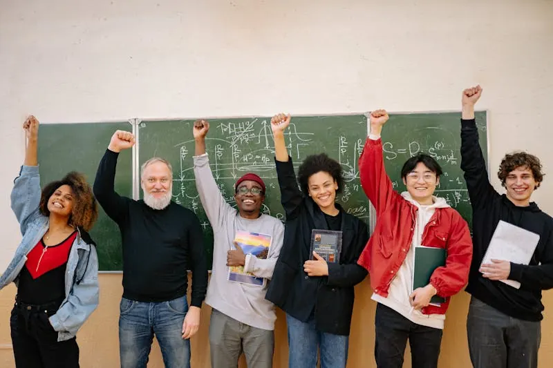 Diverse students and tutor celebrating academic success in front of a chalkboard with mathematical equations