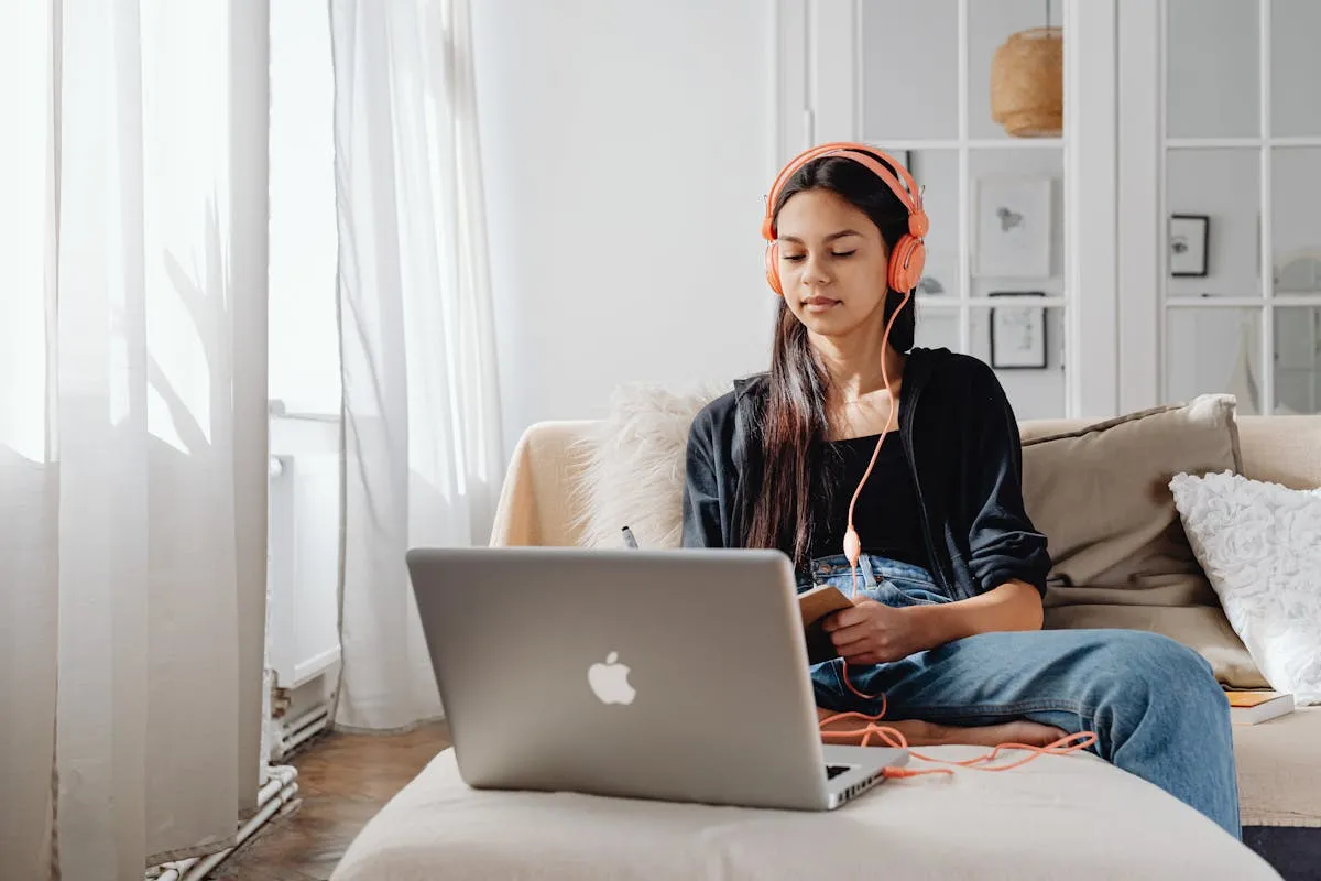 Student using laptop and headphones for online IGCSE tutoring